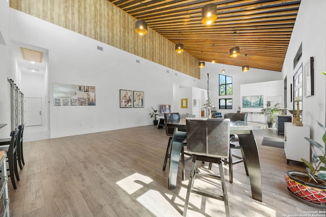 dining room featuring light hardwood / wood-style floors and high vaulted ceiling