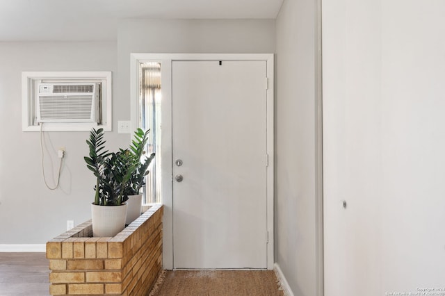 interior space with a wall mounted AC, wood-type flooring, and plenty of natural light