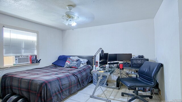 bedroom with ceiling fan, a textured ceiling, light tile patterned floors, and cooling unit