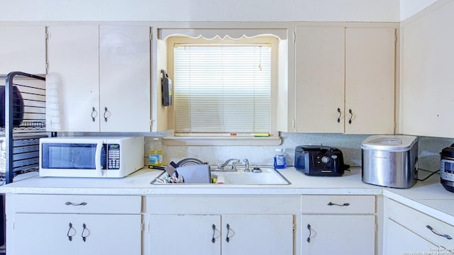 kitchen featuring white cabinets and sink