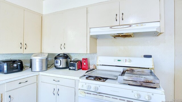 kitchen with white cabinets and white range oven