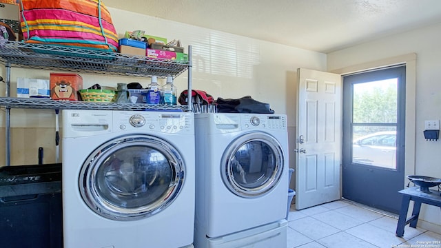 laundry room with independent washer and dryer and light tile patterned floors