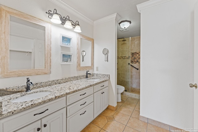 bathroom with tile patterned floors, crown molding, tiled shower, toilet, and vanity