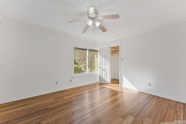 spare room featuring wood-type flooring, a textured ceiling, ceiling fan, and ornamental molding