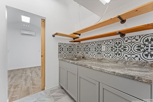 bathroom featuring a wall unit AC, tasteful backsplash, vanity, and hardwood / wood-style flooring