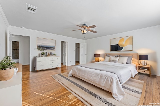 bedroom featuring ceiling fan, ornamental molding, and light hardwood / wood-style flooring