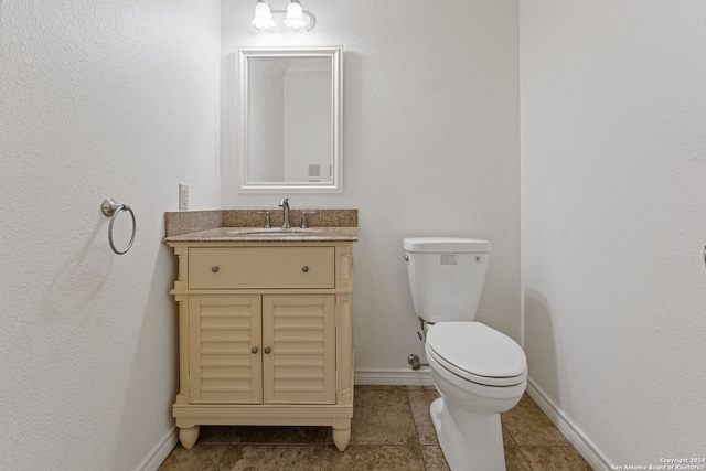 bathroom with tile patterned flooring, vanity, and toilet