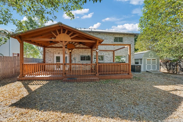 back of house with a wooden deck, central AC unit, and a storage unit