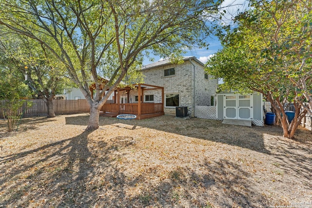 back of property with a deck, central AC unit, and a storage shed