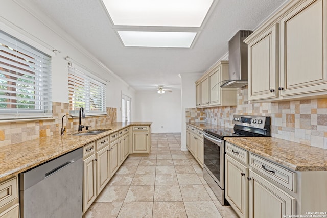 kitchen with appliances with stainless steel finishes, backsplash, crown molding, wall chimney range hood, and cream cabinetry