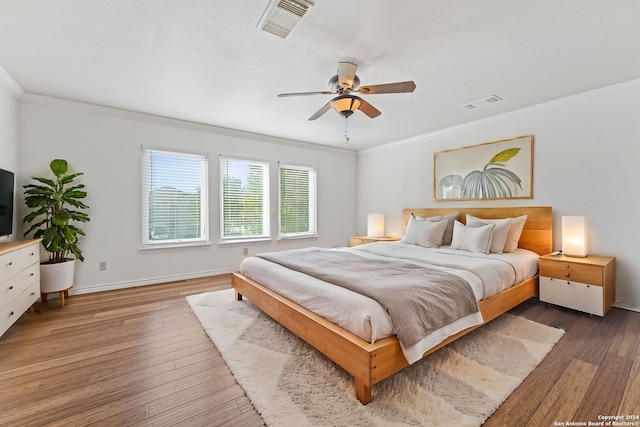 bedroom featuring hardwood / wood-style floors, ceiling fan, and ornamental molding