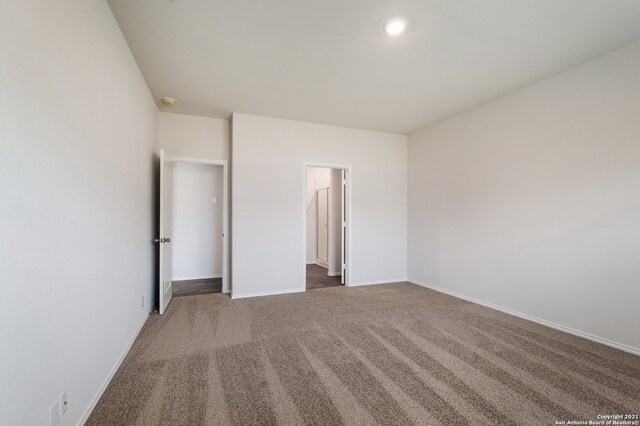 unfurnished bedroom with dark colored carpet