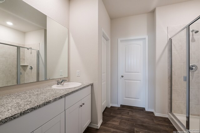 bathroom with vanity, hardwood / wood-style flooring, and walk in shower