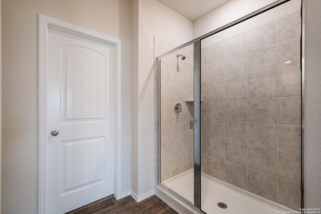 bathroom featuring hardwood / wood-style flooring and walk in shower