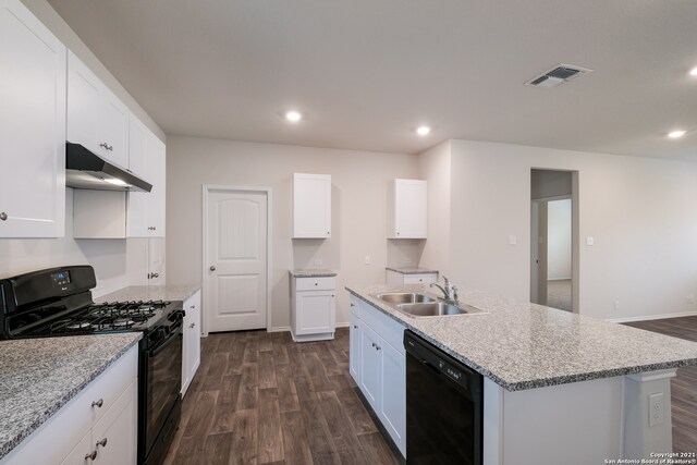 kitchen with a kitchen island with sink, dark hardwood / wood-style floors, sink, black appliances, and white cabinetry