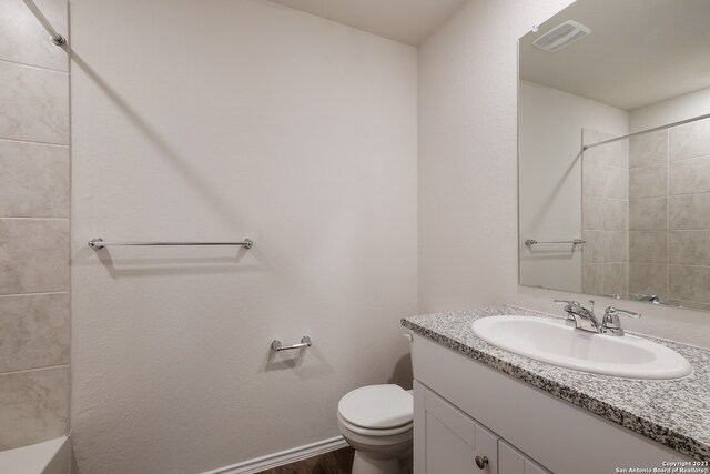 bathroom featuring vanity, hardwood / wood-style flooring, and toilet