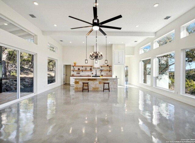 interior space with ceiling fan with notable chandelier and a towering ceiling