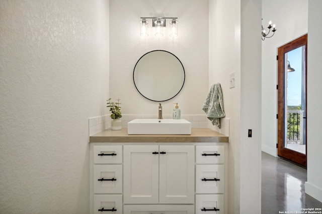 bathroom with a textured wall, concrete floors, and vanity