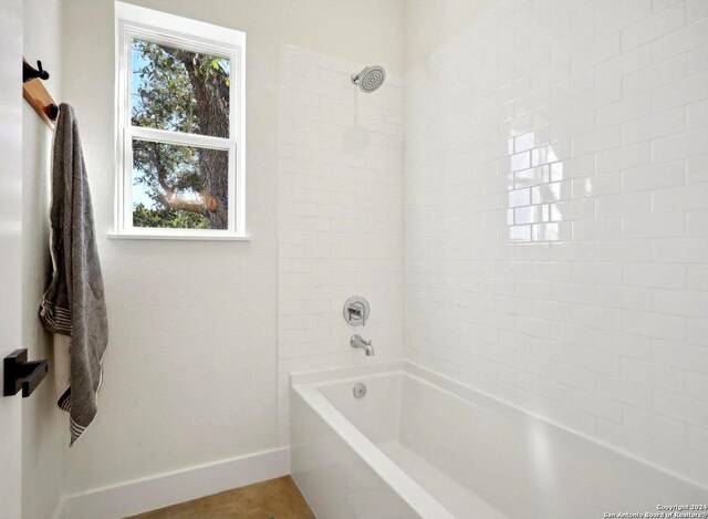 full bath featuring bathtub / shower combination and baseboards