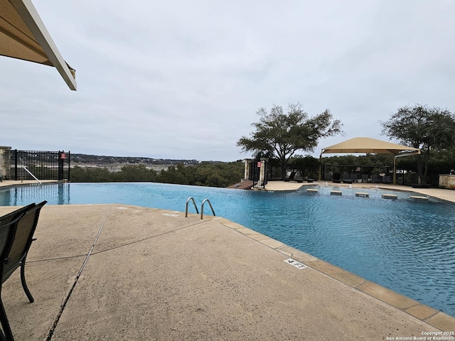 pool featuring a patio area and fence