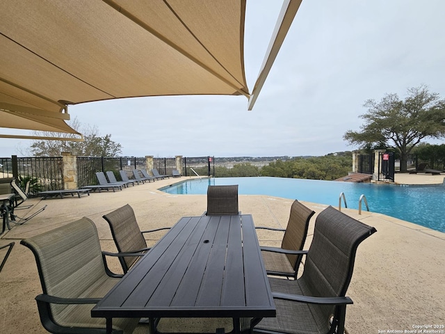 pool featuring outdoor dining area and a patio area