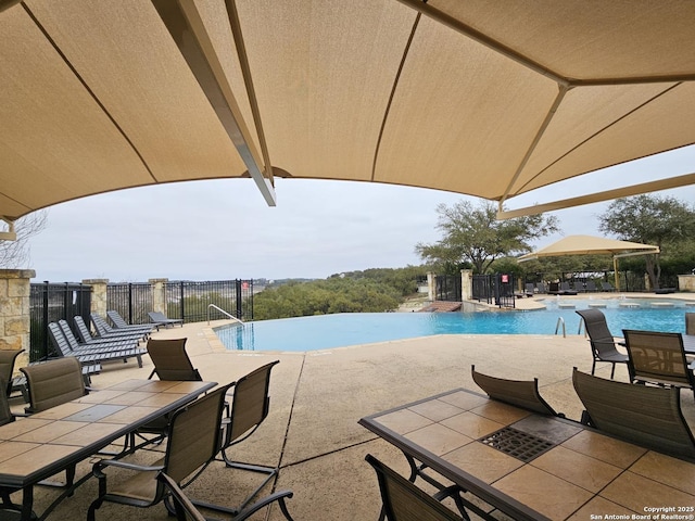 community pool featuring a patio area and outdoor dining area