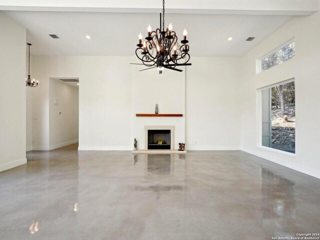 unfurnished living room with an inviting chandelier and concrete floors