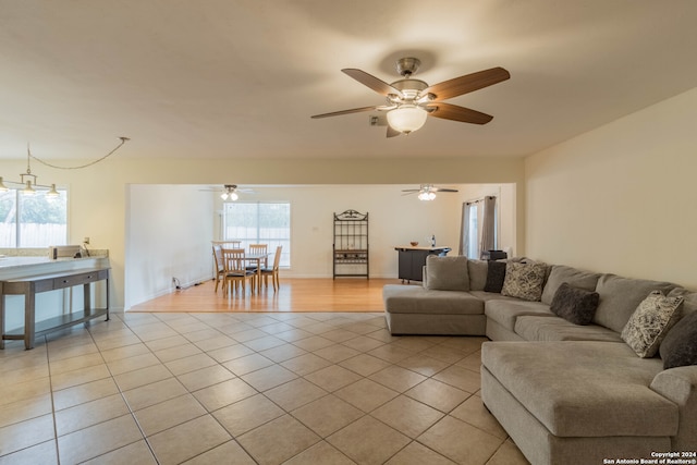 living room featuring light hardwood / wood-style flooring and ceiling fan with notable chandelier