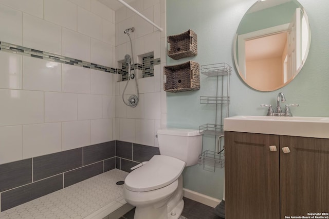 bathroom with baseboards, a tile shower, and toilet