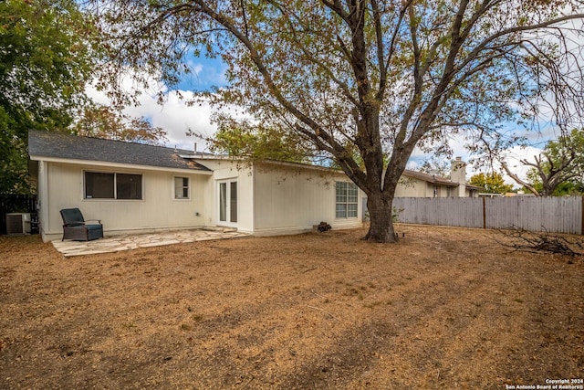 rear view of property featuring french doors, roof with shingles, a patio area, central air condition unit, and fence