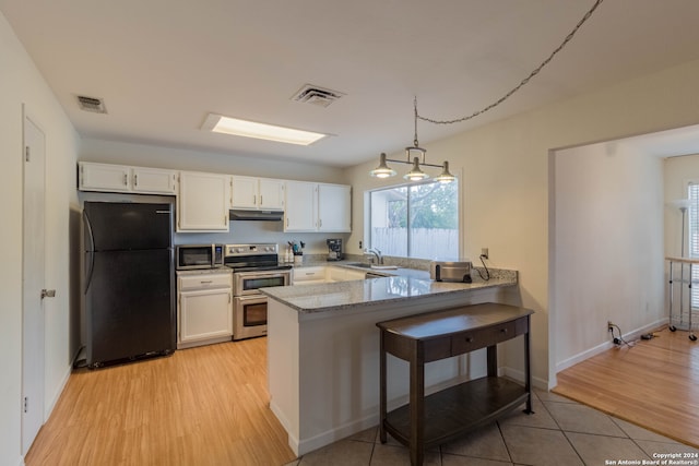 kitchen with appliances with stainless steel finishes, kitchen peninsula, decorative light fixtures, white cabinets, and light hardwood / wood-style flooring