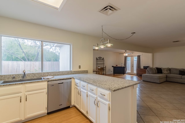 kitchen with kitchen peninsula, ceiling fan, stainless steel dishwasher, light wood-type flooring, and sink