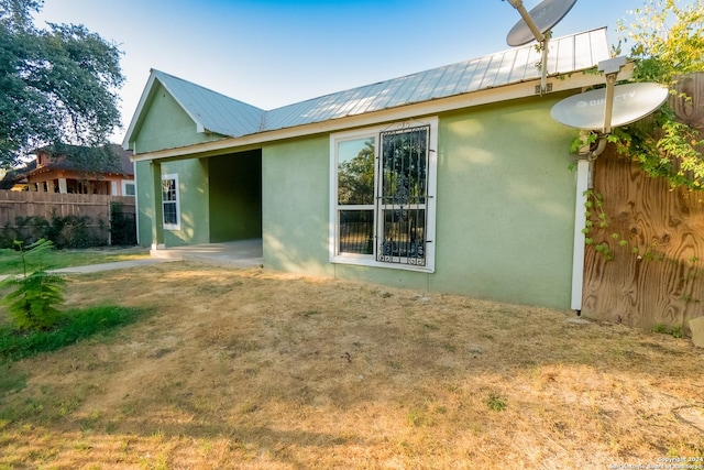 319 Vine St, San Antonio, TX 78210 - rear view of property with fence, stucco siding, a lawn, and metal roof