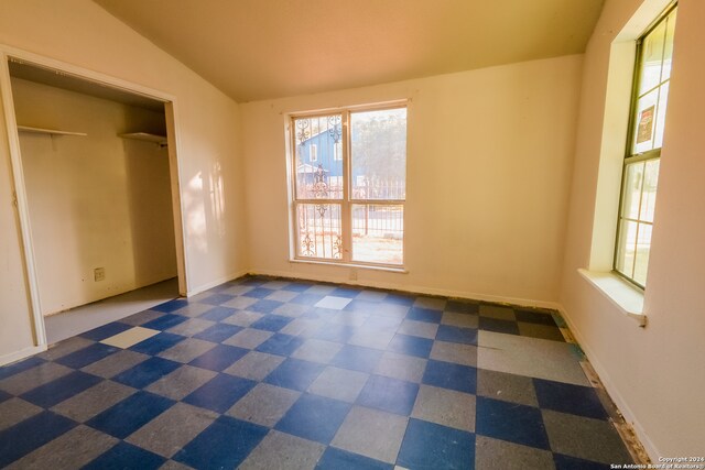 unfurnished bedroom featuring a closet and lofted ceiling