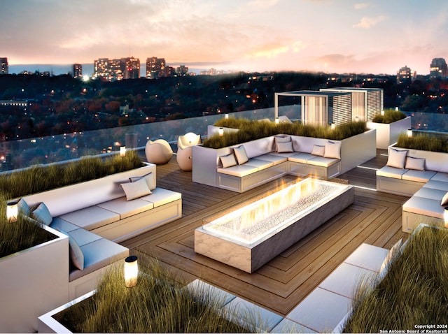 patio terrace at dusk featuring an outdoor living space with a fire pit and a deck