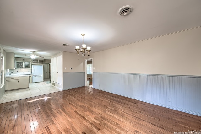 interior space with ceiling fan with notable chandelier, light hardwood / wood-style floors, and sink