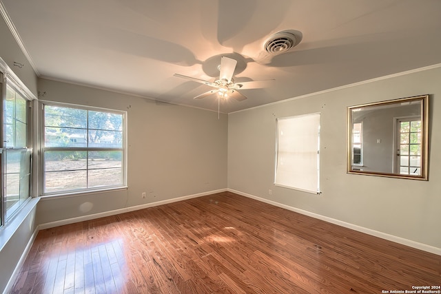 spare room featuring wood-type flooring, a wealth of natural light, crown molding, and ceiling fan