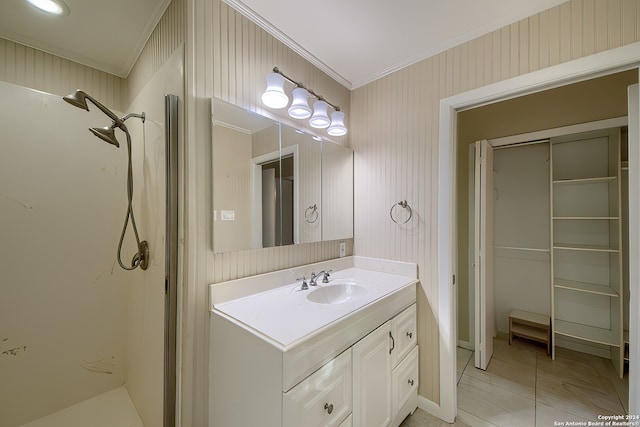 bathroom featuring vanity, crown molding, tile patterned flooring, and a shower