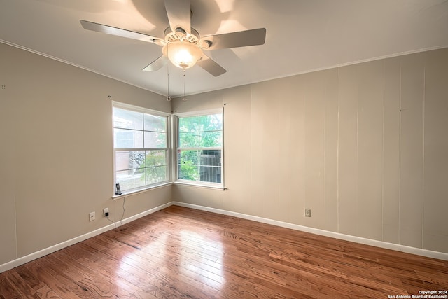 empty room with ceiling fan, ornamental molding, and hardwood / wood-style flooring