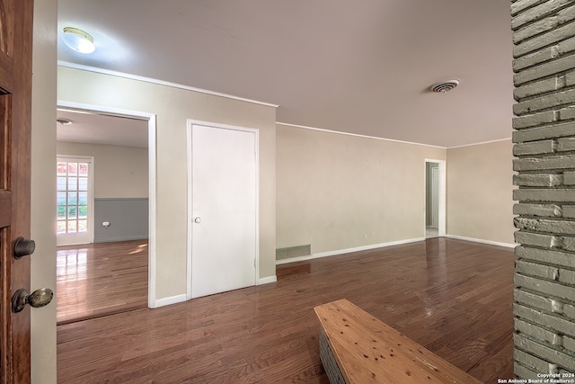 unfurnished room featuring dark hardwood / wood-style flooring and crown molding