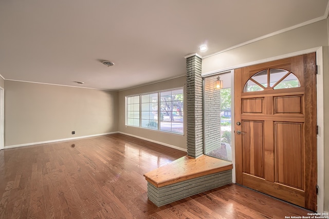 foyer entrance with wood-type flooring and ornamental molding