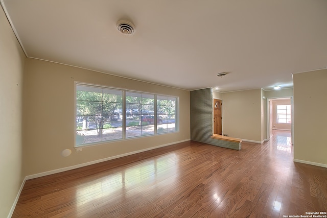 unfurnished room with hardwood / wood-style flooring and ornamental molding