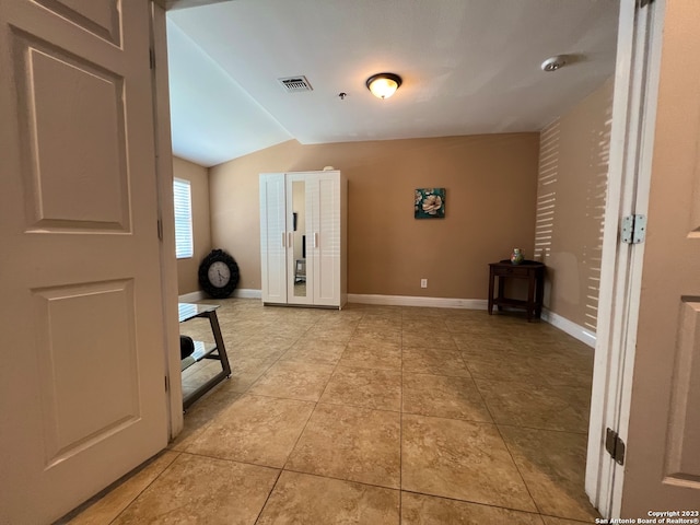 interior space with light tile patterned floors and lofted ceiling