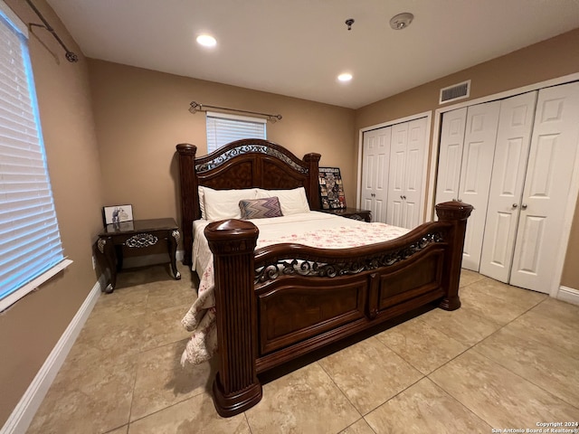 bedroom with two closets and light tile patterned floors