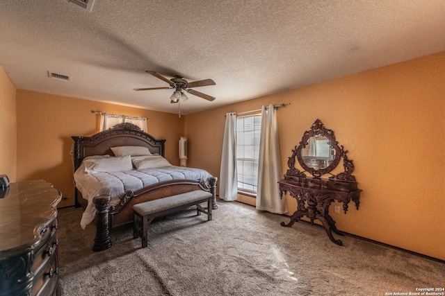 bedroom featuring ceiling fan, a textured ceiling, and dark colored carpet