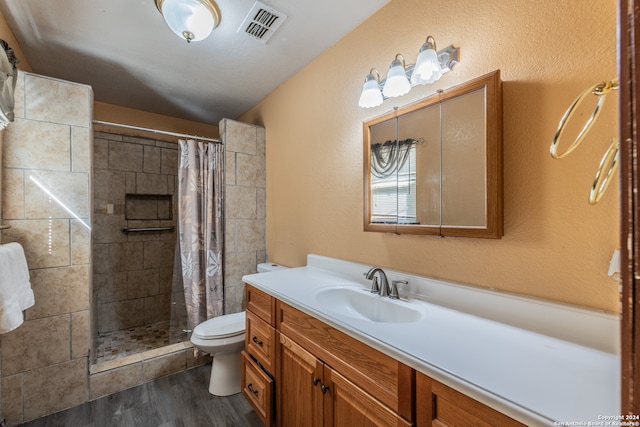 bathroom featuring vanity, toilet, curtained shower, and hardwood / wood-style floors