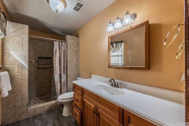 bathroom with vanity, a shower with shower curtain, hardwood / wood-style flooring, and toilet