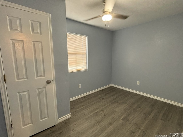 spare room featuring dark wood-type flooring and ceiling fan