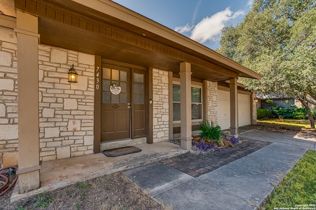 entrance to property featuring covered porch and a garage