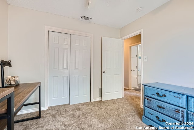 bedroom with light carpet and a closet